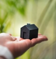 A person holding a small house in their hand